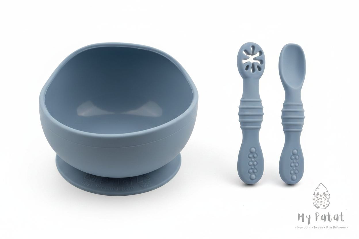 Dusty blue silicone baby suction bowl and spoons on white background