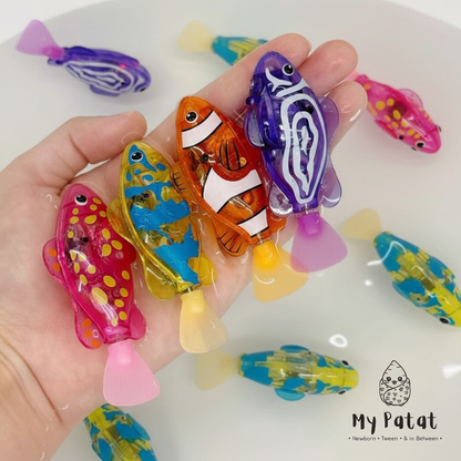 Hand holding wind-up swimming fish toys in water