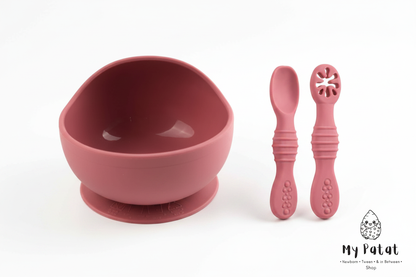 Rose pink silicone baby suction bowl and spoons on white background